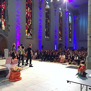 ein paar Leute stehen in einer Kirche